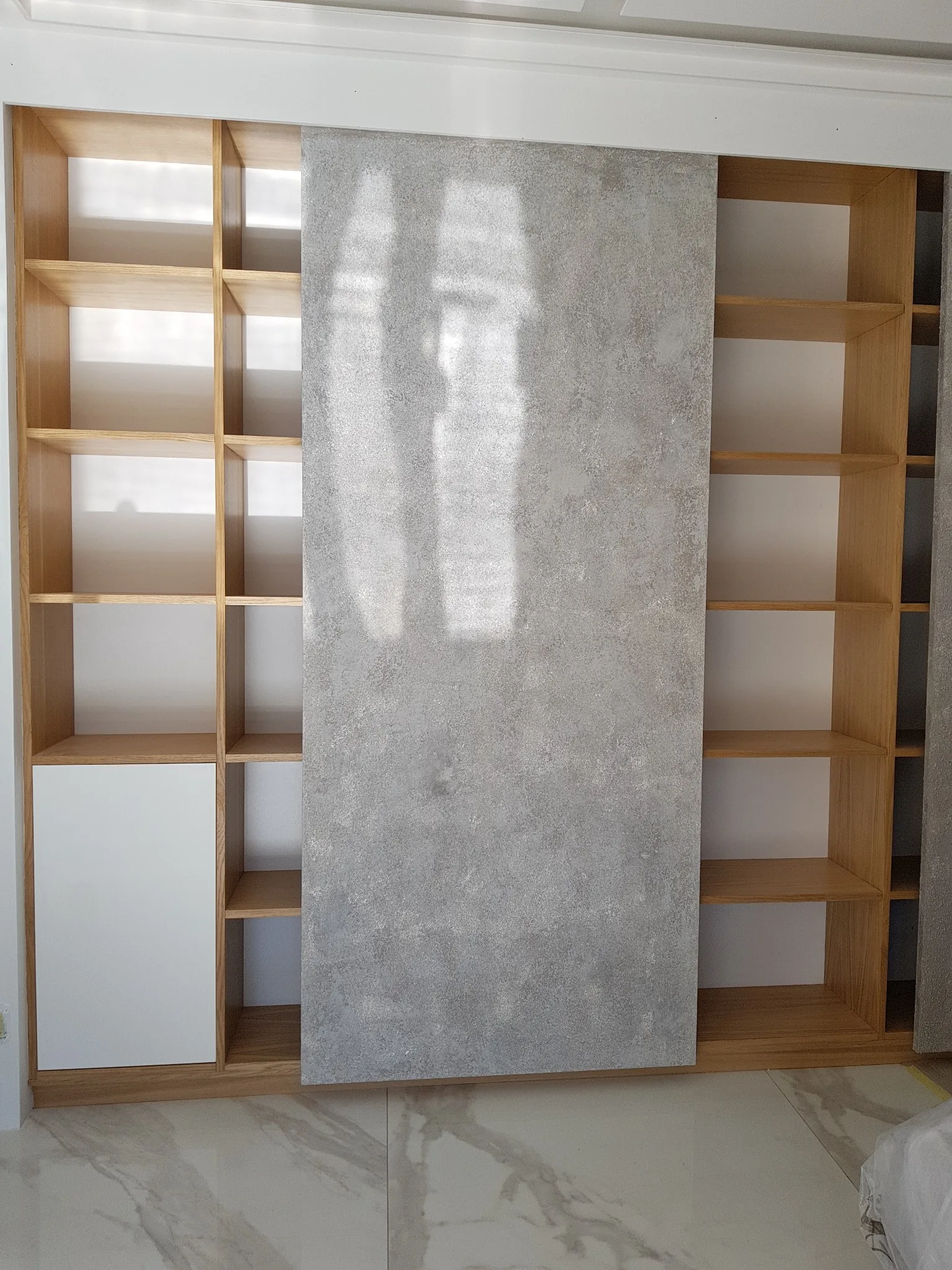 Parete attrezzata con pannelli scorrevoli e libreria in rovere